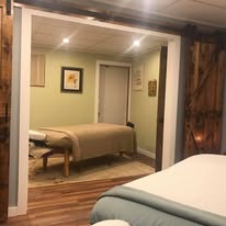 Hallway perspective showing treatment rooms with barn wood accents and warm lighting