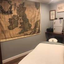 Treatment room with vintage British Isles map wall decor and massage table at Hands On Health